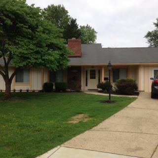 A suburban house with a driveway and a well-maintained lawn.