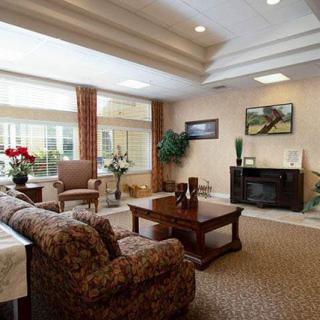A cozy and spacious living room with ample natural light, featuring comfortable furniture and elegant decor.