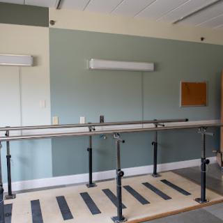 A physical therapy room equipped with walking bars for rehabilitation exercises.