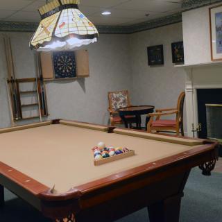 A cozy game room featuring a billiards table and dartboard.