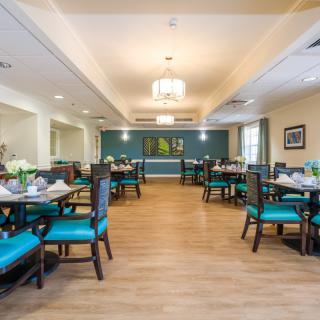 A spacious and elegantly decorated dining area with neatly arranged tables and chairs.