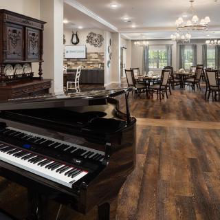 A stylish living room with a grand piano and elegant dining area.