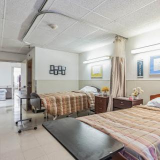 A view of a hospital room equipped with two beds and healthcare amenities.