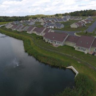 Aerial view of a suburban residential area with houses lining a small lake.