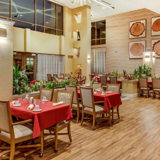 A well-decorated restaurant interior with tables set with red tablecloths.