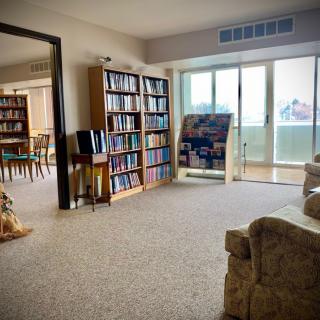 A cozy living room with bookshelves and a large window letting in natural light.
