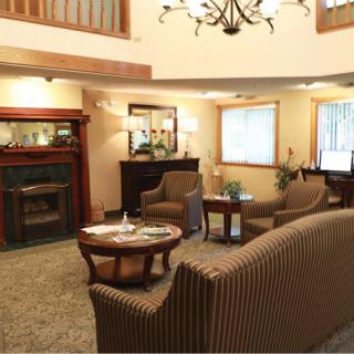 A cozy living room with a classic fireplace, comfortable seating, and elegant lighting.