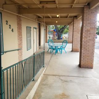 A view of the outdoor patio area with turquoise furniture outside a residential building.