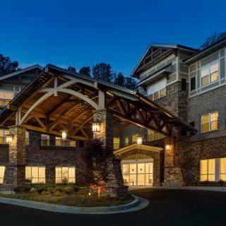 A beautifully illuminated building entrance at night with a stone facade.