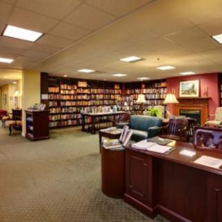 A cozy library interior with bookshelves, a reading area, and a desk.