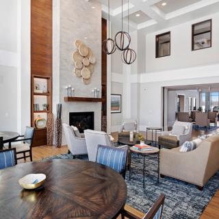 A spacious and elegantly designed living room featuring a fireplace, high ceilings, and comfortable seating.