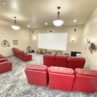 A cozy home theater featuring red seating and a large projector screen, perfect for movie nights.