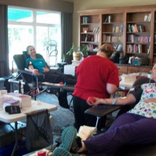 A group of people participating in a community blood donation drive at a clinic setting.