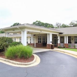 A building with a covered entrance and landscaped driveway.