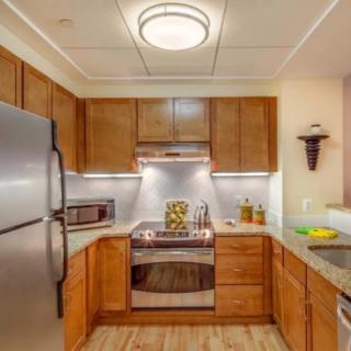 A modern kitchen with wooden cabinets and stainless steel appliances.