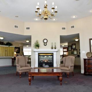 A cozy lobby with elegant furniture and a chandelier.