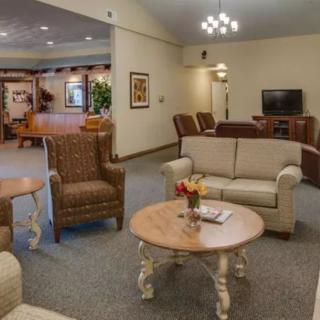 A cozy living room with comfortable sofas and chairs arranged around coffee tables.