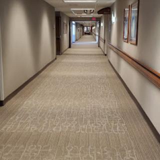 A well-lit corridor with patterned carpet and soft lighting, showcasing a modern interior design.