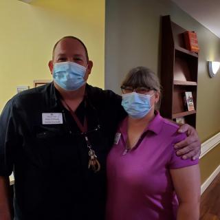 Two people wearing masks in a healthcare setting.