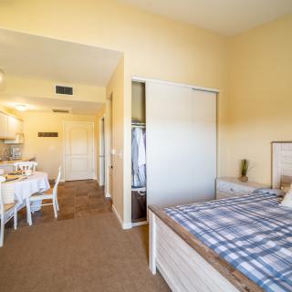 A cozy living space featuring a bedroom with a bed and a dining area, showcasing elegant interior design.