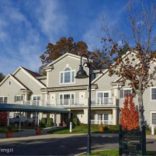 A residential building with autumn trees and a clear blue sky.