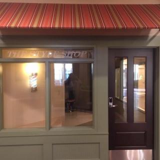 A quaint storefront with a striped awning and large windows.