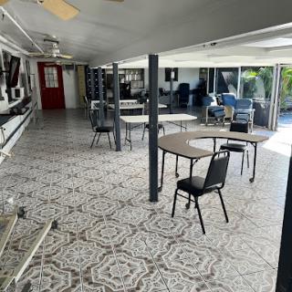 A spacious interior setting featuring tables and chairs arranged neatly on a patterned floor.