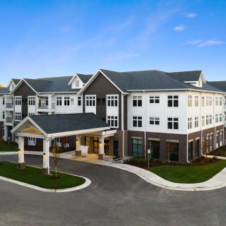 A modern residential building with a welcoming entrance, captured during the daytime.