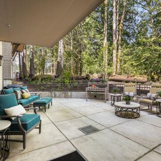 A cozy patio with comfortable outdoor seating, surrounded by a lush forest setting.