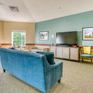 A cozy living room with a blue sofa, television, and stylish decor.