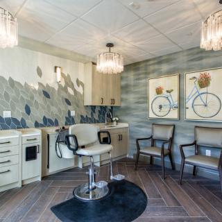 A stylish salon interior with a comfortable chair, elegant lighting, and modern decor.