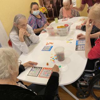A group of elderly individuals playing bingo together at a table.