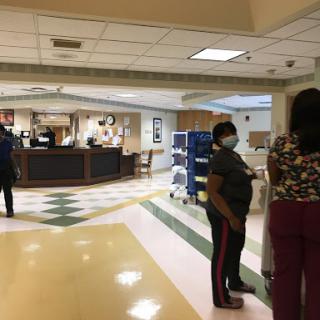A busy hospital reception area with medical staff attending to patients.