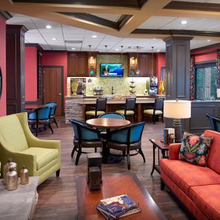 A modern lounge area with colorful seating and a bar in the background, creating a cozy atmosphere.
