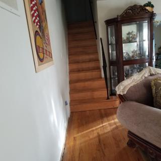 A cozy living room with a wooden staircase leading upstairs and elegant furniture.