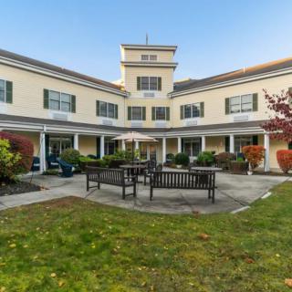 A building with a courtyard featuring benches and well-maintained landscaping.