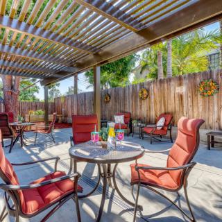 A cozy outdoor patio with red cushioned chairs under a pergola, perfect for relaxation.