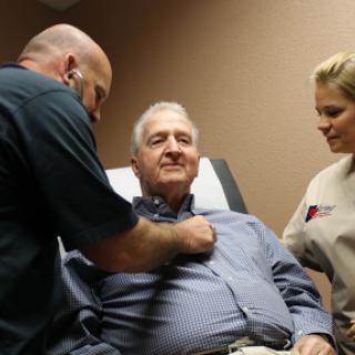 A medical professional examining a patient in a healthcare setting.