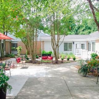 A peaceful courtyard with patio furniture surrounded by greenery.