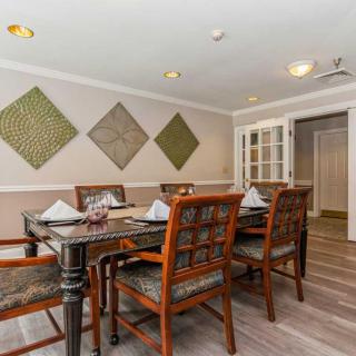 A cozy dining room with wooden furniture and decorative wall art.