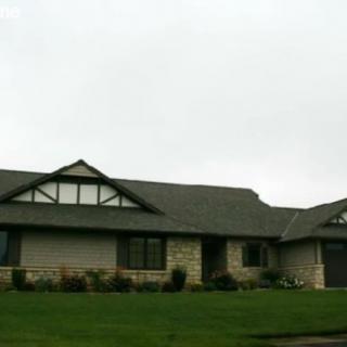 A suburban single-story house with a well-maintained lawn.