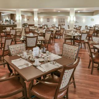 An empty dining area with neatly arranged tables and chairs in a restaurant.