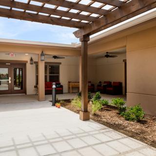 A modern courtyard with a pergola, outdoor seating, and landscaped garden.