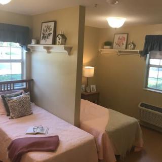 A cozy shared bedroom with twin beds, decorated with soft colors and personal touches.