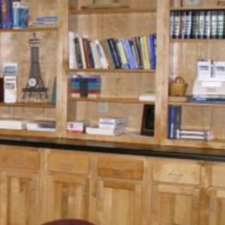 A wooden bookshelf filled with books and a small Eiffel Tower model.