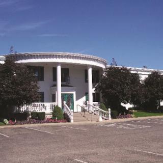 A modern building featuring classical architectural elements, surrounded by a clear blue sky.