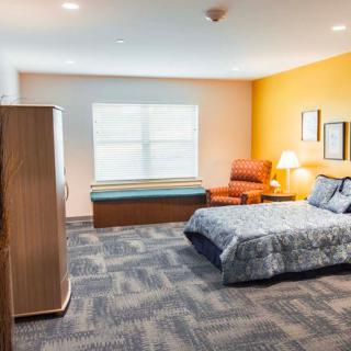 Spacious bedroom with modern furniture and bright lighting.