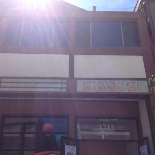 A sunlit building with a storefront and upper level windows.