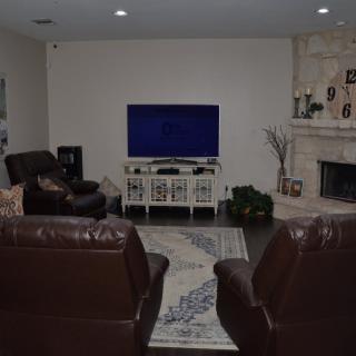 A cozy living room setup with leather couches, a television, and a fireplace.