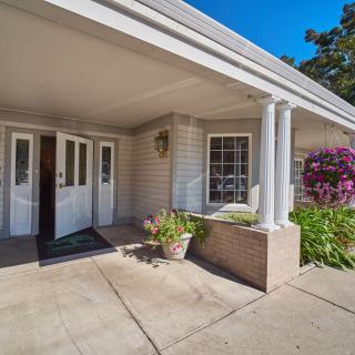 A welcoming entrance with white columns and colorful flowers.